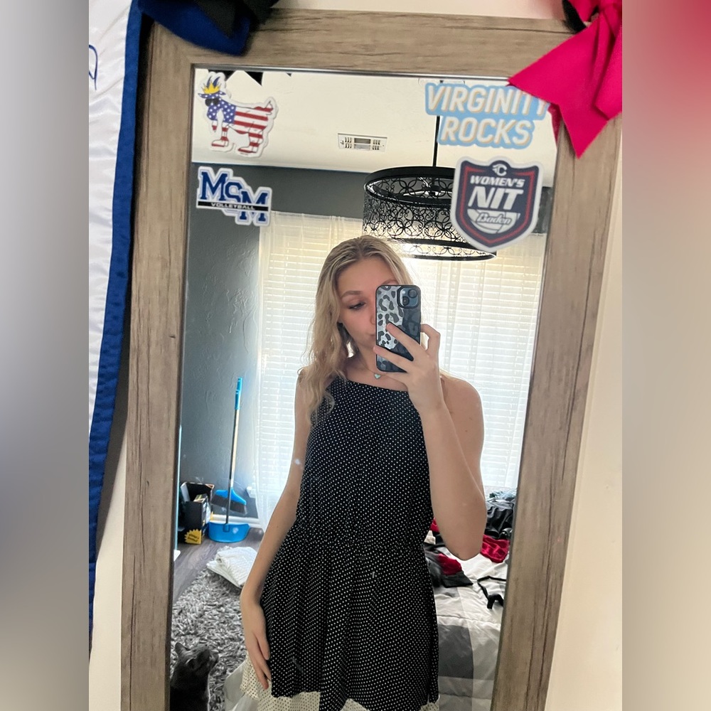 black cocktail dress. Has a white stripe with black dots at the bottom hem.